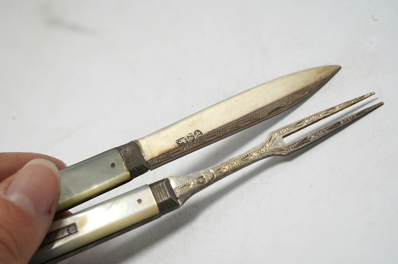 A George III mother of pearl handled silver travelling folding knife and fork, Sheffield, 1816, in original red leather case. Condition - good